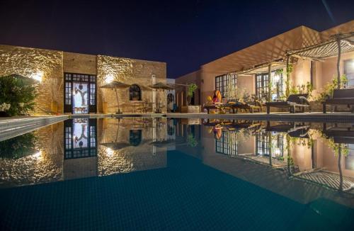 una casa con piscina di notte di Libert'Art a Essaouira