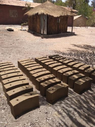 a group of bricks sitting on the ground in front of a hut at Chez Bethy Jungle et Océan in Abene