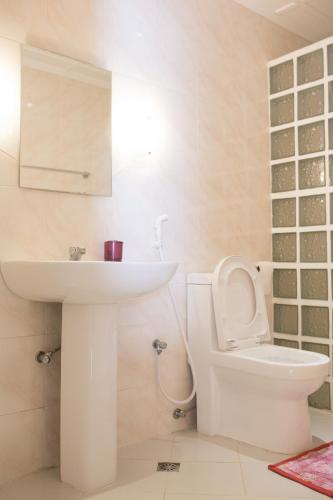 a white bathroom with a sink and a toilet at Jasmin's Room Rental in Moalboal