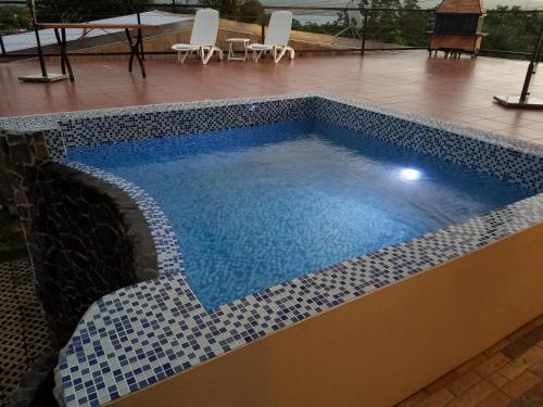 a swimming pool with blue water and white tiles at Casa Donna Rosa B&B in Nuevo Arenal