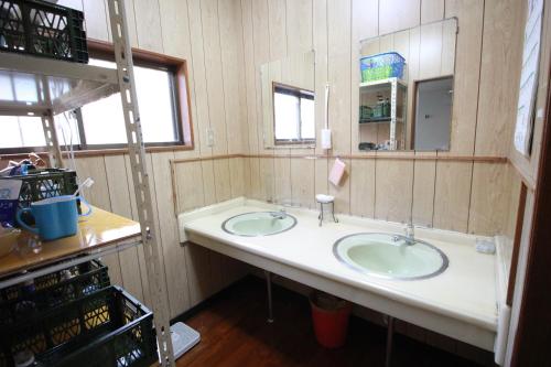 a bathroom with two sinks and a mirror at Guest House Aman in Amami