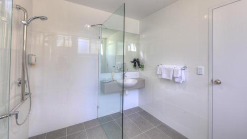 a bathroom with a glass shower and a sink at Cleveland Bay Air Motel in Cleveland