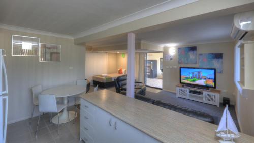 a living room with a kitchen and a living room with a tv at Cleveland Bay Air Motel in Cleveland