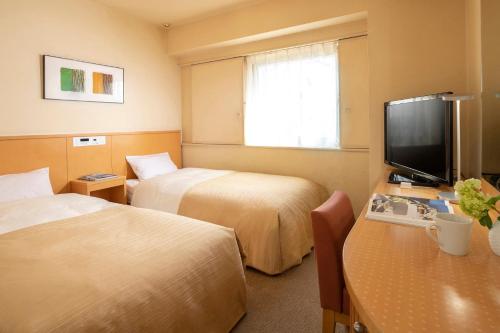 東京にあるチサンホテル浜松町のベッド2台、薄型テレビが備わるホテルルームです。