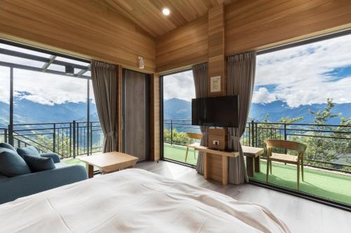 a bedroom with a bed and a large window at Chingjing Abin Minshuku in Renai
