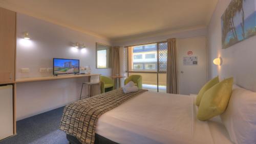 a hotel room with a large bed and a television at Cleveland Bay Air Motel in Cleveland