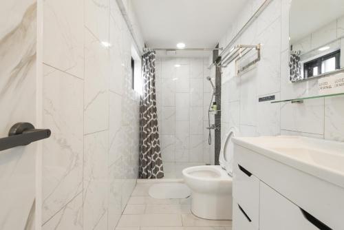 a white bathroom with a toilet and a shower at Top Sunlight Inn in Xiaoliuqiu