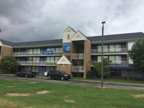 a building with two cars parked in front of it at Motel 6-Nashville, TN - Airport in Nashville