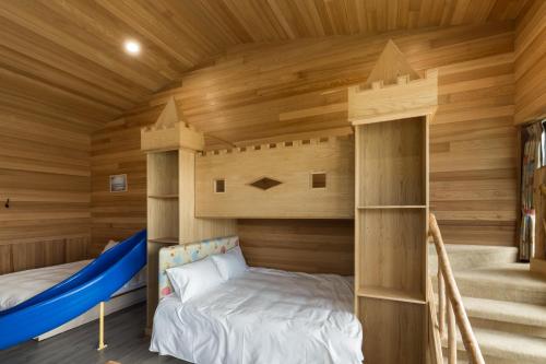 a room with a bunk bed in a wooden cabin at Chingjing Abin Minshuku in Renai