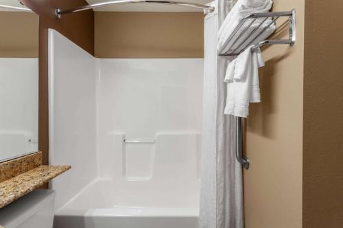 a bathroom with a shower with a white shower curtain at Microtel Inn & Suites by Wyndham Columbia in Columbia