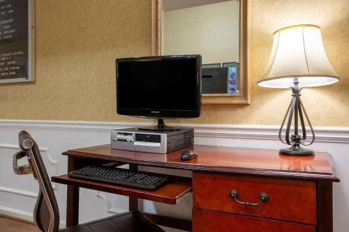 a desk with a computer monitor and a lamp on it at Baymont by Wyndham Easley/Greenville in Easley