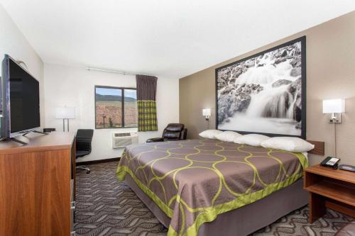 a hotel room with a bed and a flat screen tv at Super 8 by Wyndham Dubois in Dubois