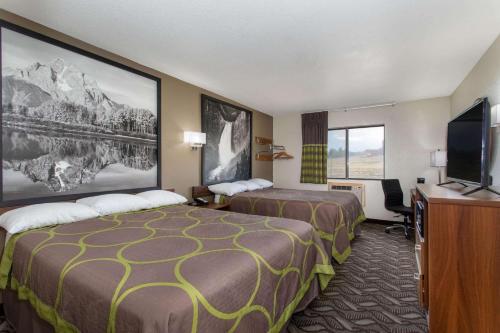 a hotel room with two beds and a flat screen tv at Super 8 by Wyndham Dubois in Dubois