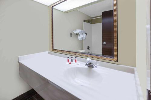 a bathroom with a sink and a mirror at Days Inn by Wyndham Milan Sandusky South in Milan