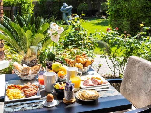 a blue table with breakfast foods on it at Mercure Maurepas Saint Quentin in Maurepas