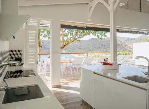 a kitchen with a view of a table and chairs at Villa Ondines in Les Anses-dʼArlets