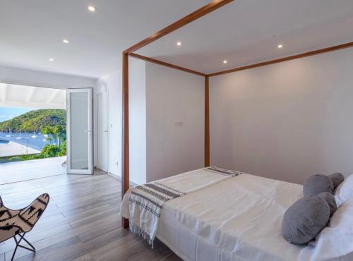 a bedroom with a large bed and a chair at Villa Ondines in Les Anses-dʼArlets