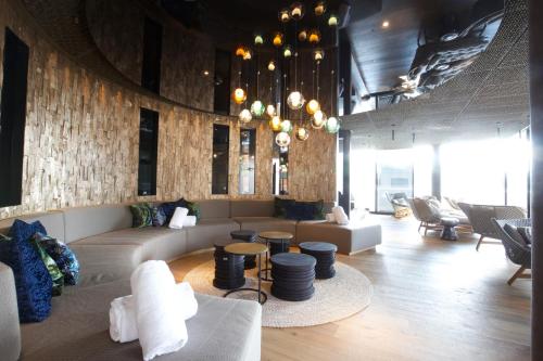 a living room with a couch and tables and chairs at The Hide Flims Hotel in Flims