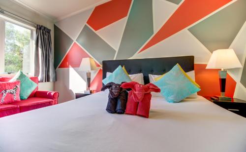 two stuffed animals sitting on a bed in a room at Silver Fern Lodge in Taupo
