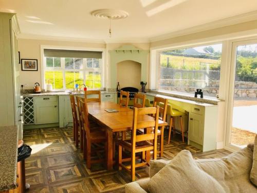 a kitchen with a wooden table and chairs in a room at Maggie janes cottage Carlingford omealth in Ó Méith