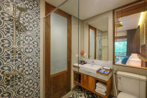 a bathroom with a sink and a mirror at Sagara Candidasa by AHM in Candidasa
