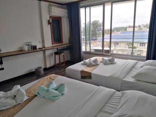 Postel nebo postele na pokoji v ubytování Pimpimarn Hotel