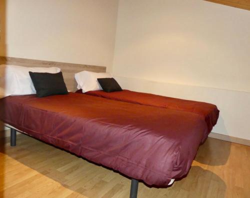 1 dormitorio con 2 camas con sábanas rojas en DÚPLEX Acollidor al Centre de Vic APTGARBI en Vic