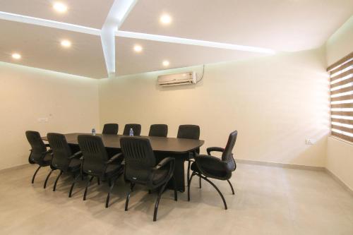 a conference room with a table and black chairs at Hotel Kairali in Palakkad