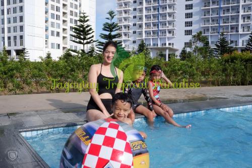 un grupo de personas sentadas en una piscina en PS4+NETFLIX+TV PLUS Tagaytay Tropical Staycation at SMDC en Tagaytay