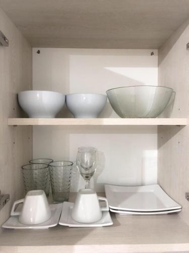 a kitchen with white bowls and bowls on shelves at AIRES VERDES PREMIUM in Salta