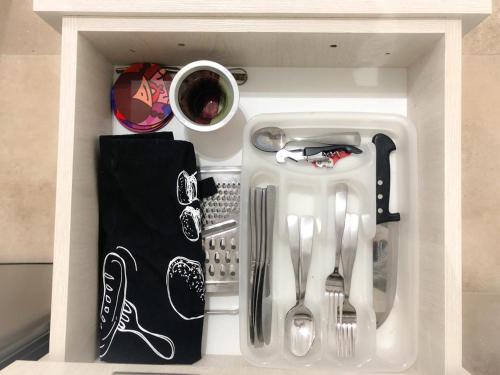 a white drawer filled with utensils in a kitchen at AIRES VERDES PREMIUM in Salta