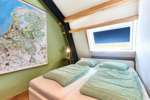 two beds in a small room with a map on the wall at ROYAAL APPARTEMENT CENTRUM MIDDELBURG in Middelburg