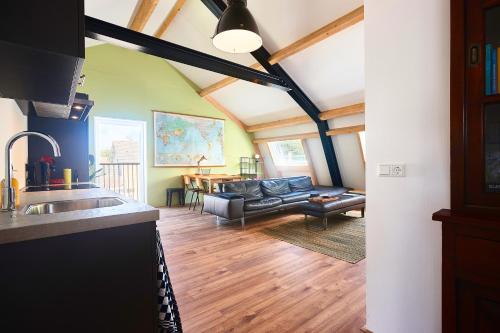 a kitchen and a living room with a couch at ROYAAL APPARTEMENT CENTRUM MIDDELBURG in Middelburg