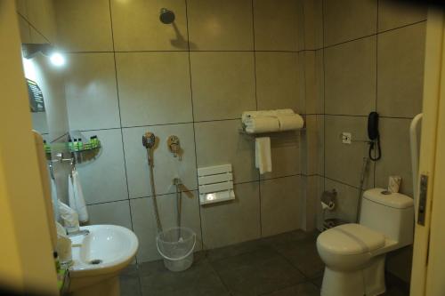a bathroom with a toilet and a sink at The Hotel Chettungal in Angamaly