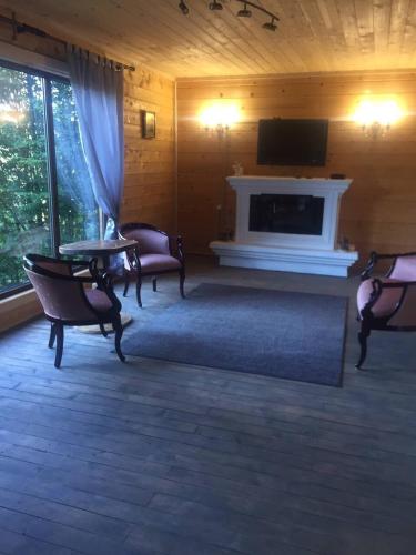 a living room with a fireplace and a tv at RIVIERA in Lekechi