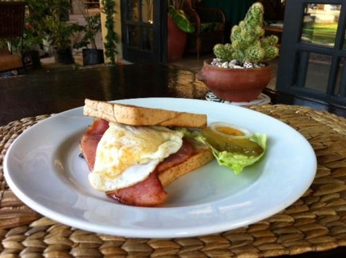 a white plate with a breakfast sandwich with egg and toast at Playa Papagayo Beach Inn in Olongapo