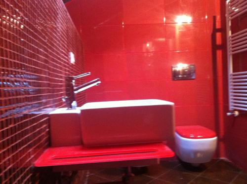 a red bathroom with a sink and a toilet at Villa Gioia in Acqui Terme