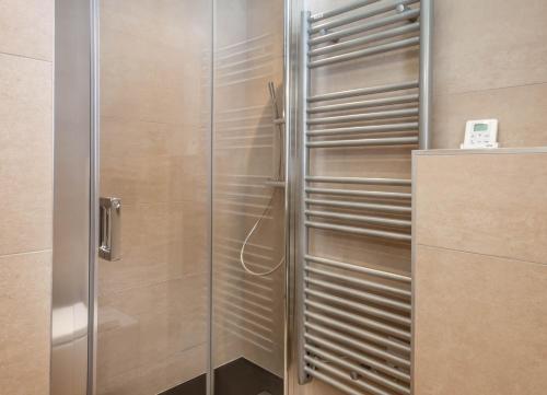 une douche avec une porte vitrée dans une salle de bain dans l'établissement Portes du Pleney 104, à Morzine