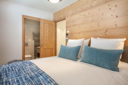 une chambre avec un lit avec des oreillers bleus et blancs dans l'établissement Portes du Pleney 104, à Morzine
