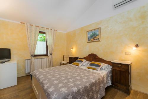 a bedroom with a bed and a television in it at B&B Carmela in Umag