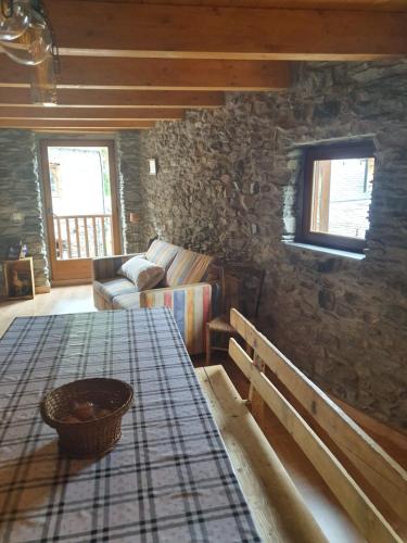 a living room with a table and a stone wall at Casa Garrabet in Durro
