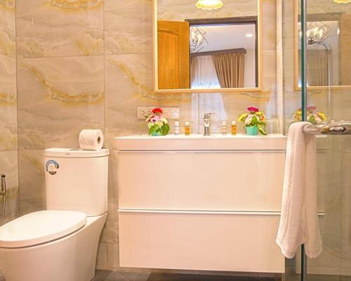 a bathroom with a toilet and a sink and a mirror at V One Pride-Sukhumvit 22, Bangkok in Bangkok