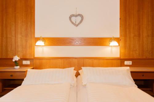 a bedroom with two beds and a heart on the wall at Rainberghof***, Appartements in Rauris