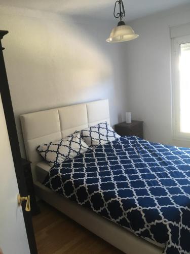 sypialnia z niebiesko-białą kołdrą na łóżku w obiekcie Apartamento Alcobaca w mieście Alcobaça