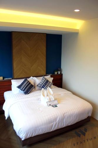 a bedroom with a large white bed with blue walls at W Station in Bangkok