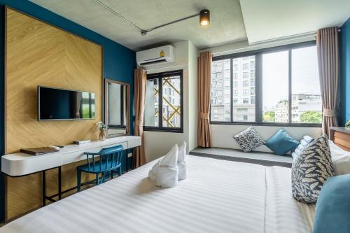 a hotel room with a bed and a desk and a television at W Station in Bangkok