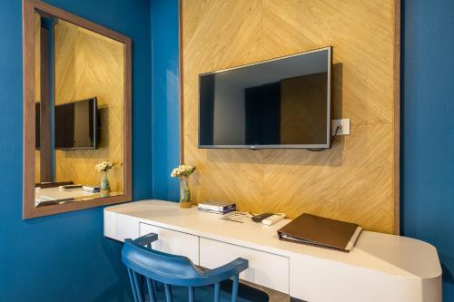 a room with a desk with a tv and a blue wall at W Station in Bangkok