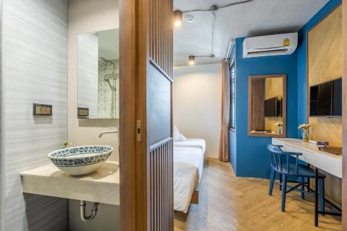 a bathroom with a sink and a bed in a room at W Station in Bangkok