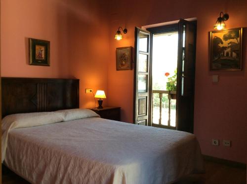 een slaapkamer met een bed en een open raam bij La Foina in Ceceda de Abajo