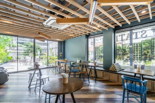 a restaurant with tables and chairs and large windows at W Station in Bangkok